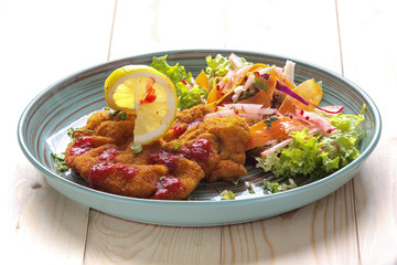 Meat in batter with vegetables on a plate