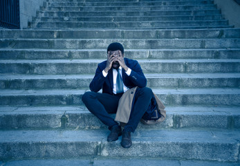 Fototapeta na wymiar Sad business man suffering from depression in total despair hopeless and frustrated in city stairs