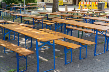 Before the party begins: empty wooden tables and benches in the shadow