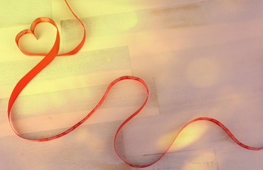 Heart of red bow on wooden background, copy space