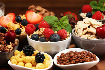 Cereal. Bowls of various cereals, berries and milk for breakfast. Muesli with kids cereals.