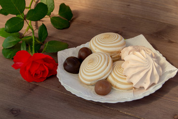 Marshmallow and rose on dark table dark background