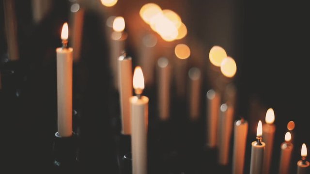 Close up HD footage of burning candles inside a church, with focus transition.