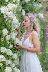 Fototapeta premium Portrait of a young woman in a park of roses