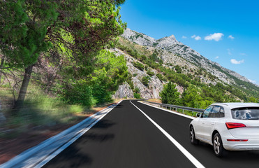 White car rushes along the road to the sea. Motion blur effect.