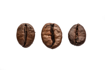 Three roasted coffee beans isolated on white background, macro photo