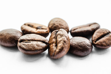 Coffee beans on white background, macro photo. Brown aromatic roasted seeds