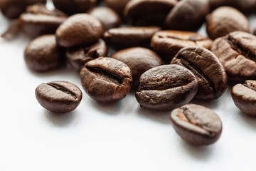 Coffee beans on white background, macro photo. Brown aromatic roasted seeds