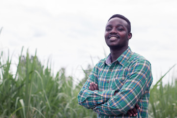 African Farmer with hat stand in the  green farm