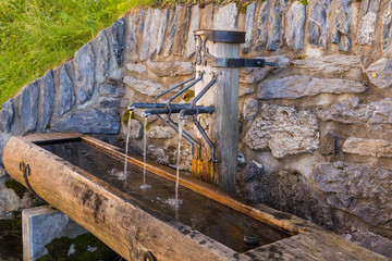 Drinking water fountain in vintage town Murren in highland Switzerland.