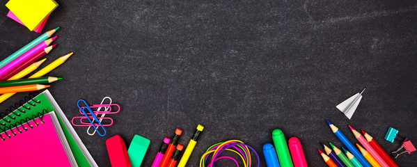 School supplies corner border banner. Overhead view on a chalkboard background with copy space....