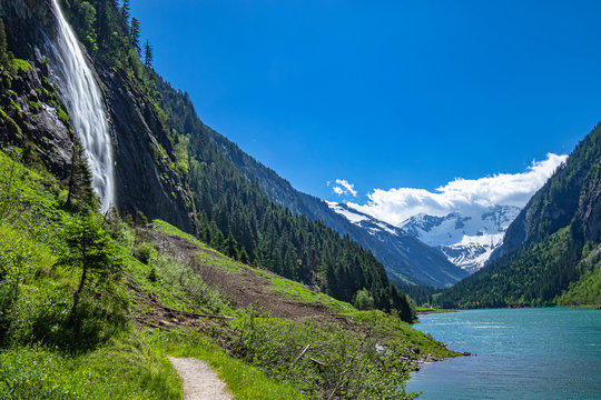 Alps mountains with blue lake and waterfall. Photo taked at Stillup Lake, Austria, Tyrol Region