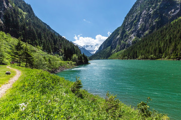 Fototapeta na wymiar Hiking trail around mountain lake. Alps mountains, Stillup Lake, Austria, Tyrol Region