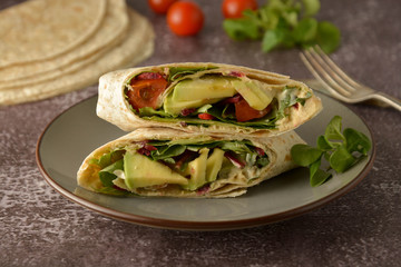 Tortilla wraps with avocado, cherry tomato. Healthy, vegan food. Take away snack.