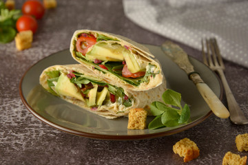 Tortilla wraps with avocado, cherry tomato. Healthy, vegan food. Take away snack.
