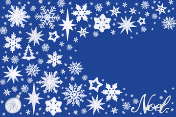 Christmas decorations with silver Noel sign forming an abstract background on blue with copy space. Traditional symbols for the festive season.