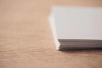 selective focus of white empty business cards on wooden surface