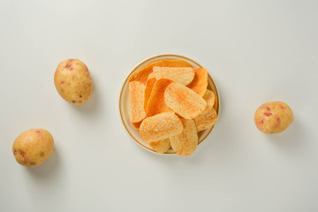 Potato chips in a plate isolated on a white background. Fast food snack.