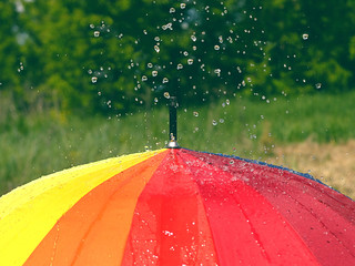Rain on Rainbow Umbrella. bright colorful umbrella and water drops. rainy weather. rainy season background. copy space. soft selective focus