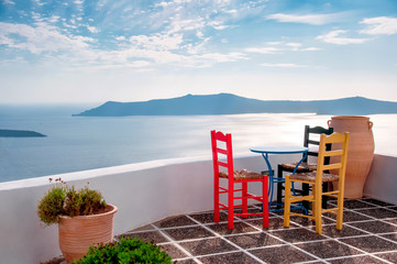 White architecture on Santorini island, Greece, Aegean sea, Europe. Beautiful summer landscape, sea view. Restaurant with table and chairs, caldera view. Famous travel destination
