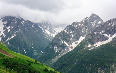 Dombay mountain range in the Caucasus in summer, snow-capped peaks and green mountain slopes