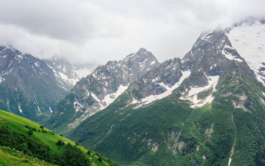 Fototapeta na wymiar Dombay mountain range in the Caucasus in summer, snow-capped peaks and green mountain slopes