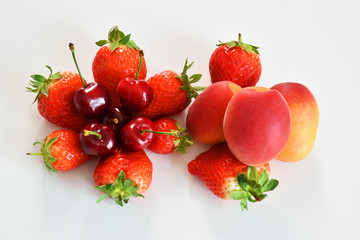 top view of assorted fruits strawberries apricot cherries on a white background