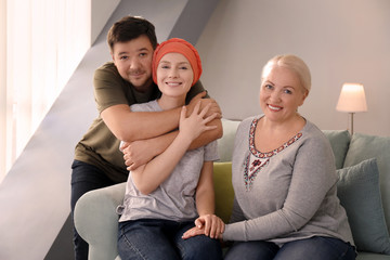 Family visiting young woman with cancer indoors