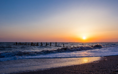 Fototapeta na wymiar Sea coast with waves at sunset