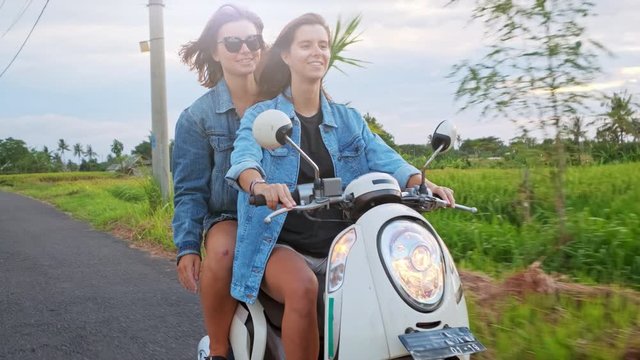 Young attractive couple of fashionable hipsters or millennials driving towards new exciting travel destination on motorbike on mountain forest road.