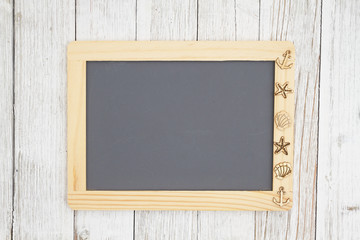 Blank chalkboard with nautical objects on weathered whitewash textured wood background