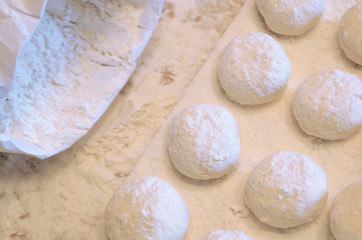 concept of baking bread. round soft dough for baking. board with cheesecakes and sprinkled flour. bag of white flour. soft focus.