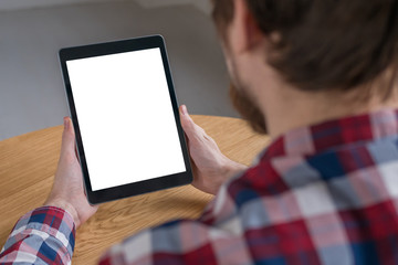 Over shoulder closeup view: man hands holding digital tablet computer device with white blank...