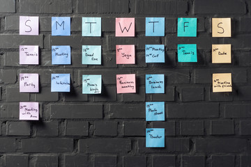 colorful sticker notes on black brick wall