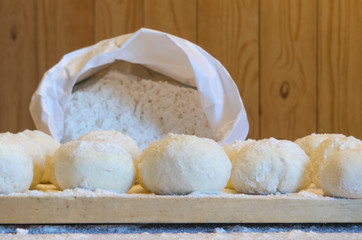 concept of baking bread and baking. soft dough for baking, cheesecakes and bread. knead and sculpt the dough. wheat flour in a white package on a separate background. soft focus.