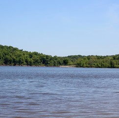 A view of the calm lake in the park on a sunny day.