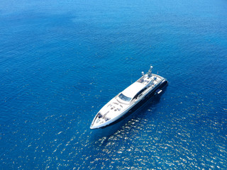 Aerial view of luxury private yacht in the blue sea during summer. Big yacht sailing in open waters. Santorini, Greece. 