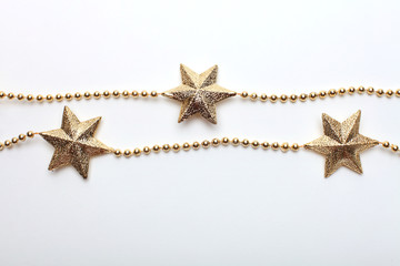 Fototapeta na wymiar Gold star and bead garland on white backgroun. Flat lay. Top view.