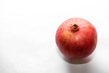 Fototapeta na wymiar Juicy ripe pomegranate on white background. Whole pomegranate