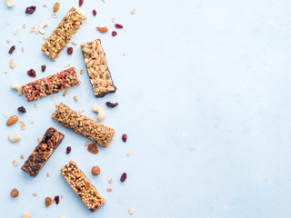 Granola bar on blue background. Set of different granola bars on white marble table. Shallow DOF. Top view or flat lay. Copy space for text.