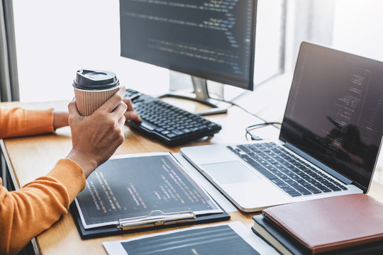 Young Professional programmer working at developing programming and website working in a software develop company office, writing codes and typing data code, Programming with HTML, PHP and javascript