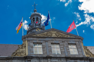 Close up of the Maastricht City hall and bell tower built in the 17th century in a classicist baroque style and was designed by Pieter Post against an amazing blue sky with dramatic clouds