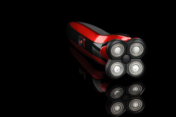 Closeup electrical red shaver, haircut isolated on the black mirror background with copy space