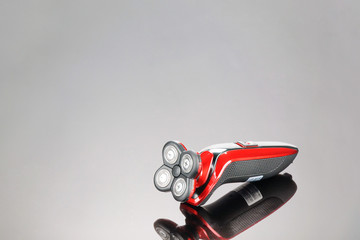 Electrical red shaver, haircut isolated on the grey mirror background with copy space