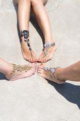 Chick vacation vibe concept. Women legs with leg jewellery on the tropical white sand beach. Nisi beach in Aya Napa resort summer vibe.