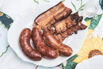 roasted bacon and sausages served on the table