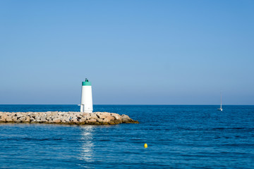 Fototapeta na wymiar Small lighthouse on habours gate