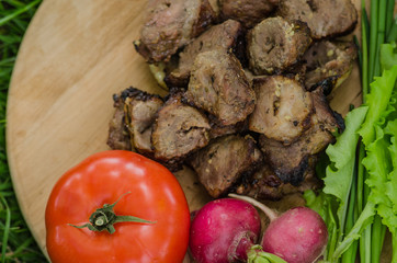 shashlik with vegetables on wooden background on nature. Russian food concept