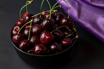cherries in black containers on the table