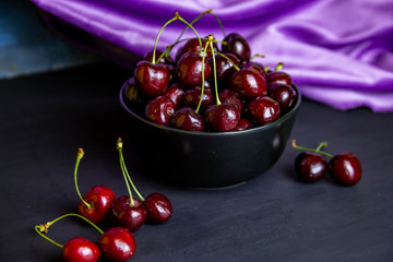 cherries in black containers on the table